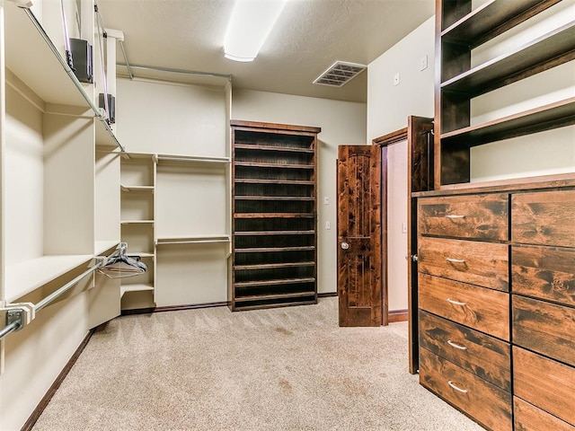 spacious closet with light colored carpet