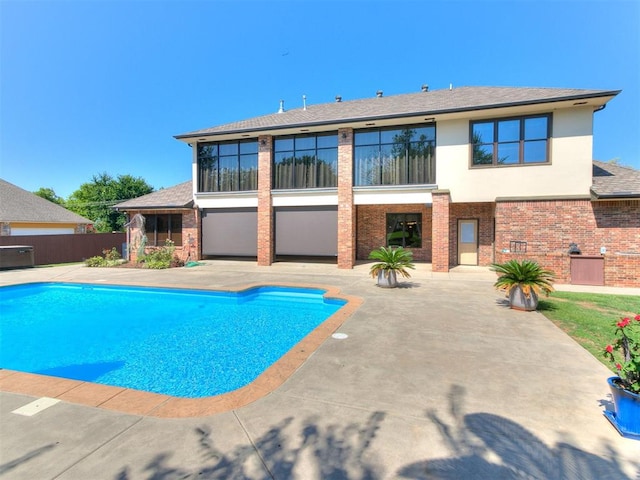 back of house featuring a fenced in pool, brick siding, stucco siding, a patio area, and fence