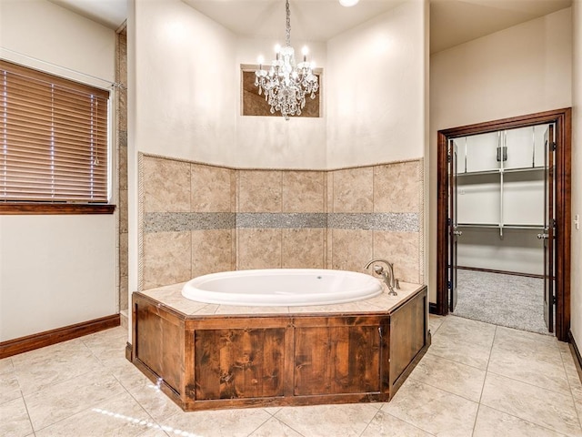 full bathroom featuring tile patterned floors, an inviting chandelier, baseboards, and a bath