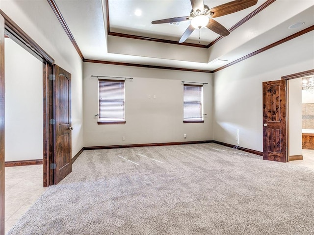 unfurnished bedroom with a tray ceiling, carpet, and crown molding