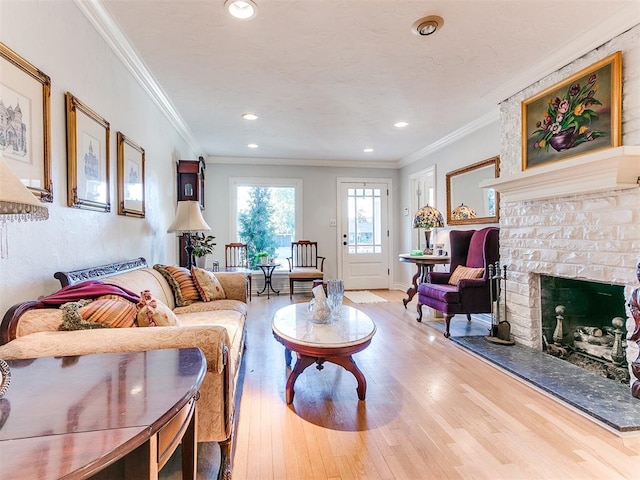 living room featuring ornamental molding, a fireplace, and light hardwood / wood-style flooring