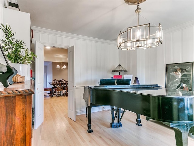 misc room featuring crown molding, a notable chandelier, and light hardwood / wood-style flooring