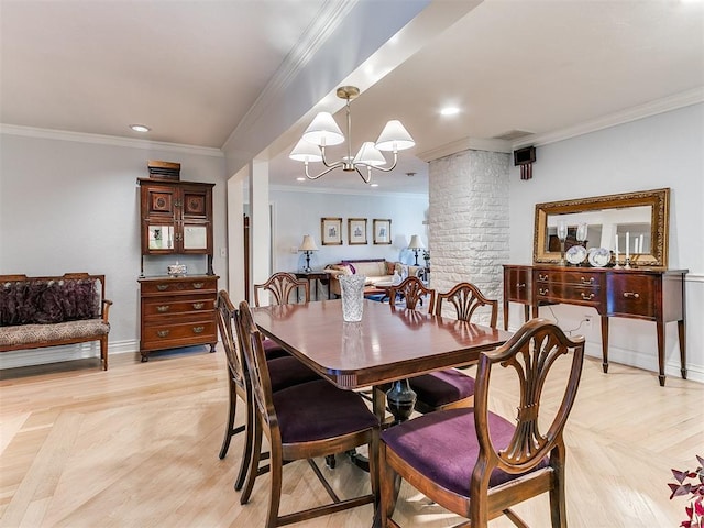 dining room with ornamental molding, a chandelier, light parquet floors, and ornate columns