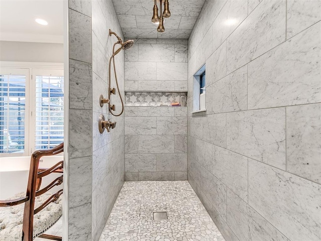 bathroom with a tile shower and crown molding