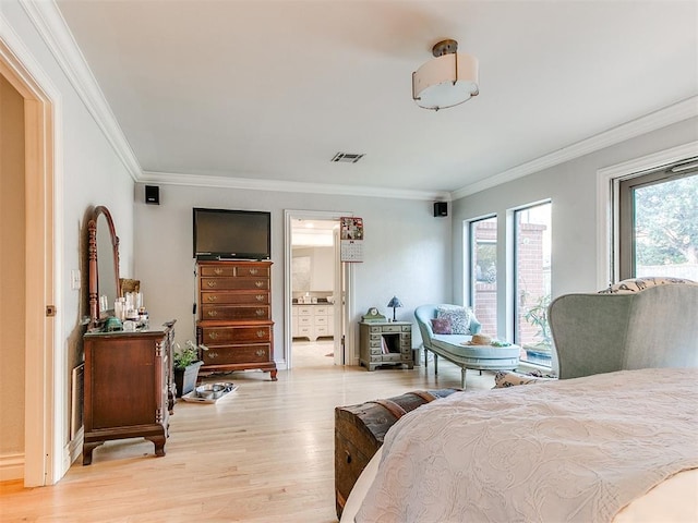 bedroom featuring crown molding, ensuite bathroom, and light wood-type flooring