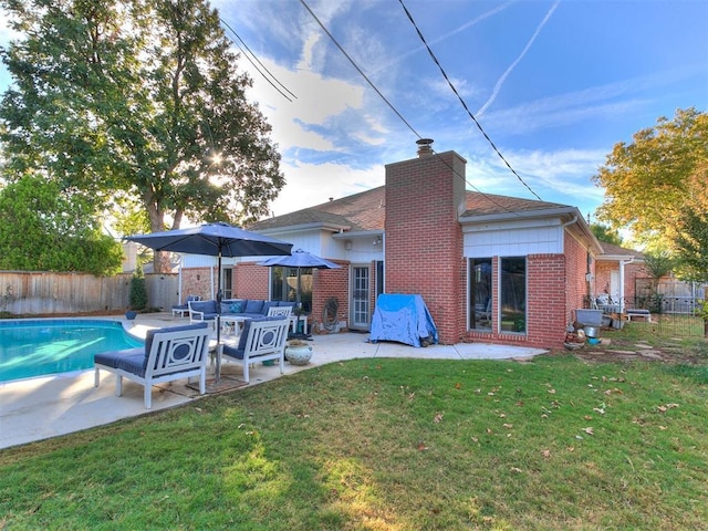 back of property featuring an outdoor hangout area, a fenced in pool, a patio area, and a lawn