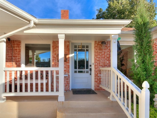 entrance to property with brick siding and a chimney