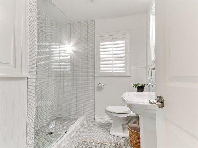 bathroom featuring tile patterned floors, a stall shower, and toilet