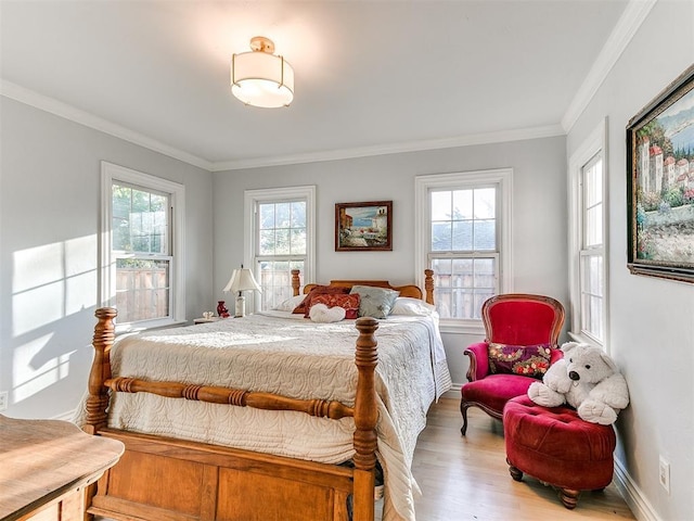 bedroom featuring baseboards, wood finished floors, and ornamental molding