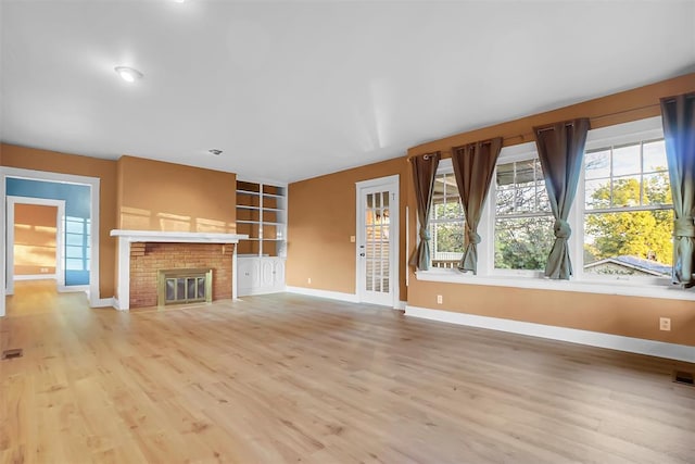 unfurnished living room with a fireplace and light hardwood / wood-style floors