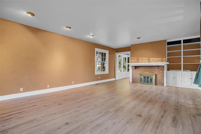 unfurnished living room featuring a fireplace and light hardwood / wood-style flooring