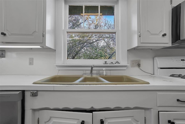 603 N College St, Cordell, OK 73632 - kitchen featuring a sink, dishwashing machine, white cabinetry, and light countertops