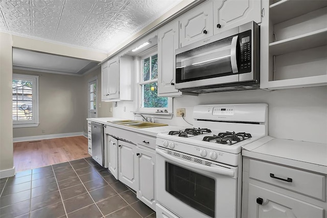 kitchen with white cabinets, dark hardwood / wood-style flooring, stainless steel appliances, and a healthy amount of sunlight