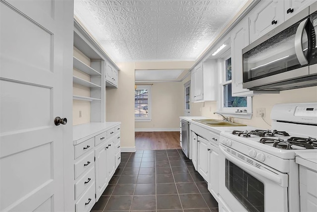 603 N College St, Cordell, OK 73632 - kitchen featuring appliances with stainless steel finishes, a sink, light countertops, and an ornate ceiling