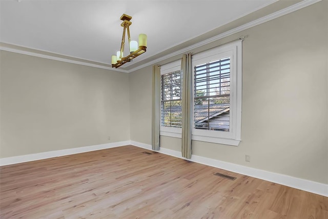 unfurnished room with light hardwood / wood-style floors, crown molding, and a notable chandelier