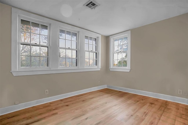 unfurnished room featuring light wood-type flooring and plenty of natural light