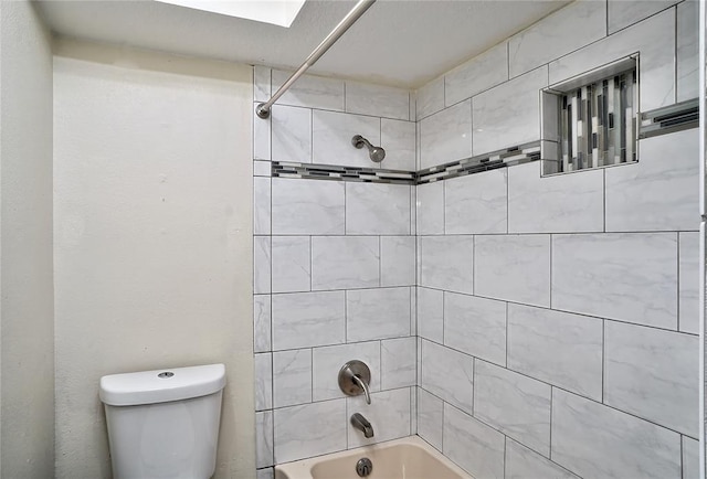 bathroom with toilet and tiled shower / bath