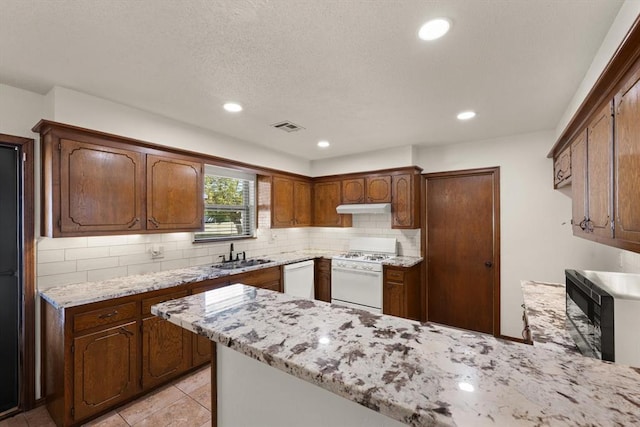 kitchen featuring sink, tasteful backsplash, light stone counters, white appliances, and light tile patterned floors