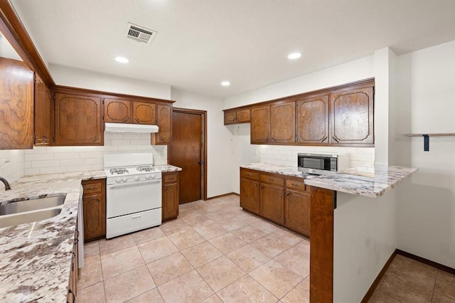 kitchen featuring kitchen peninsula, decorative backsplash, sink, and white range