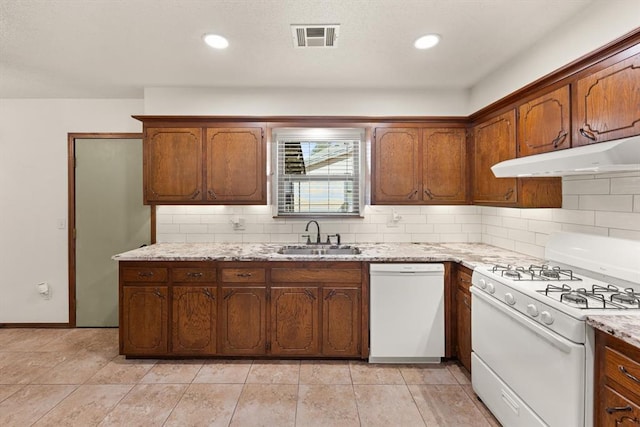 kitchen with sink, light stone counters, backsplash, white appliances, and light tile patterned floors