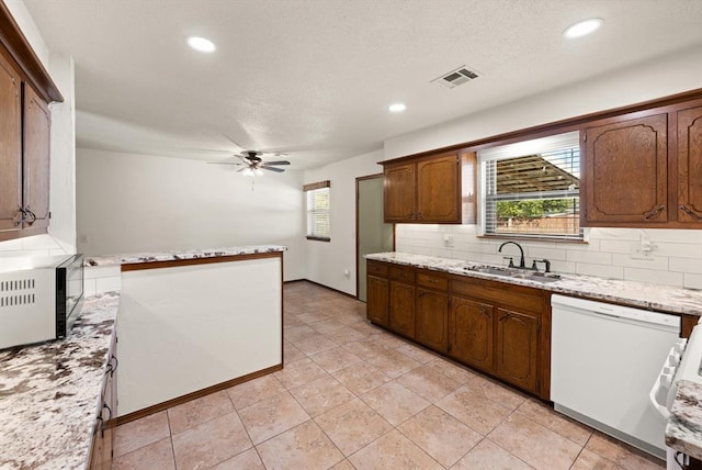 kitchen with dishwasher, sink, ceiling fan, tasteful backsplash, and light tile patterned flooring