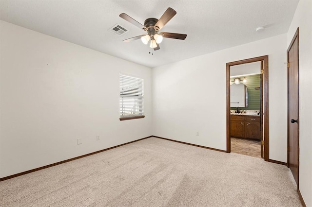 unfurnished bedroom with light carpet, connected bathroom, and ceiling fan