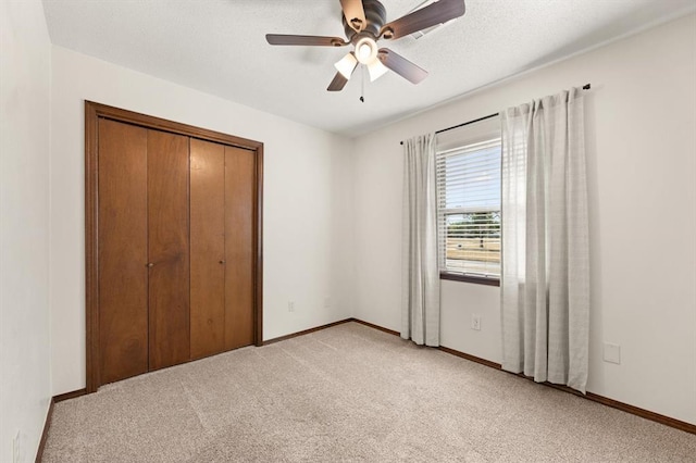 unfurnished bedroom with ceiling fan, a closet, and light carpet