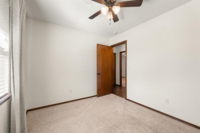 carpeted spare room with ceiling fan