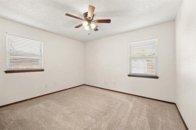 empty room with ceiling fan, a textured ceiling, and light carpet