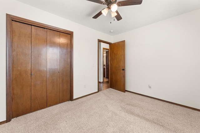 unfurnished bedroom featuring light carpet, a closet, and ceiling fan