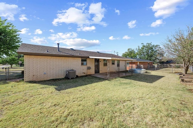 rear view of house with a yard, a patio, and central air condition unit