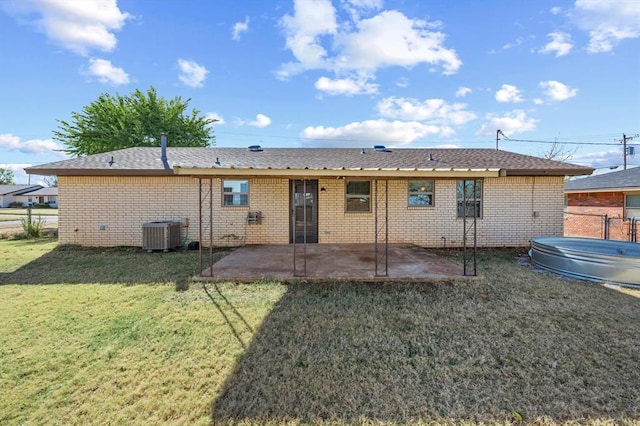 back of house with a yard, central AC unit, a patio area, and a swimming pool