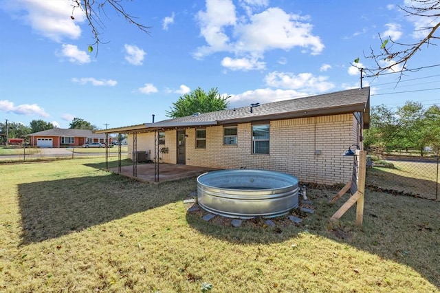 rear view of property featuring a yard and a pool