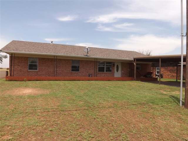 back of property with a carport and a yard