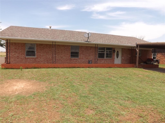 rear view of property featuring a lawn and a carport