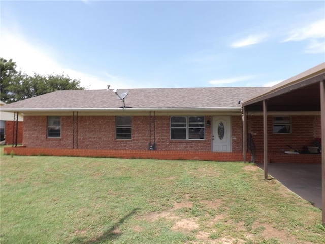 back of house featuring a carport and a lawn