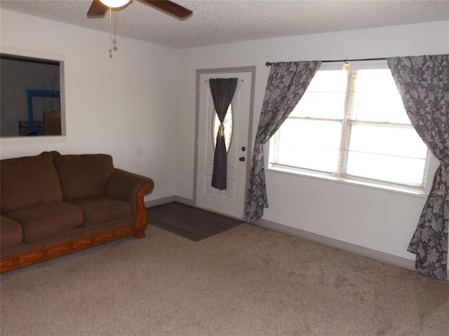 carpeted living room featuring a textured ceiling and ceiling fan