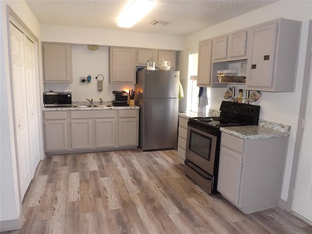 kitchen featuring gray cabinets, sink, light hardwood / wood-style floors, and appliances with stainless steel finishes