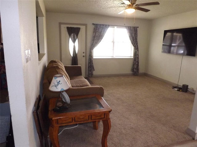 carpeted living room with ceiling fan and a textured ceiling