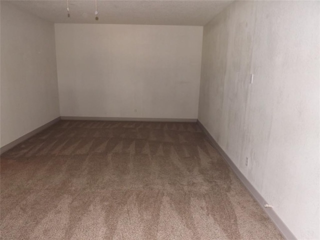 unfurnished room with dark colored carpet