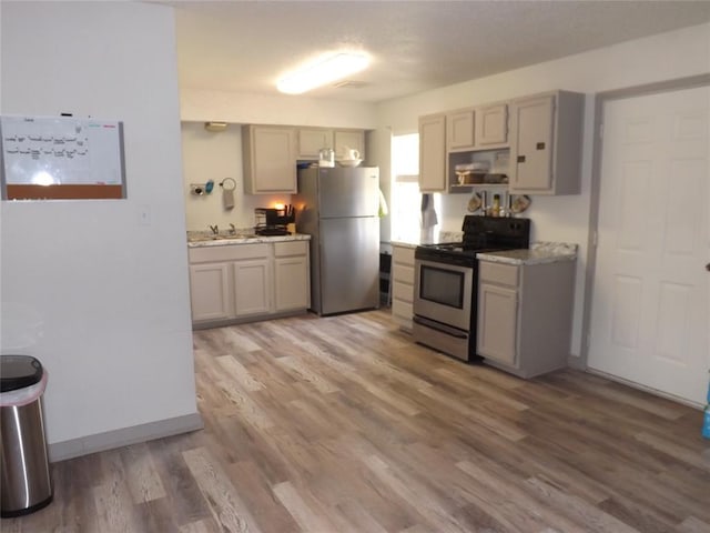 kitchen with hardwood / wood-style floors, gray cabinetry, and stainless steel appliances