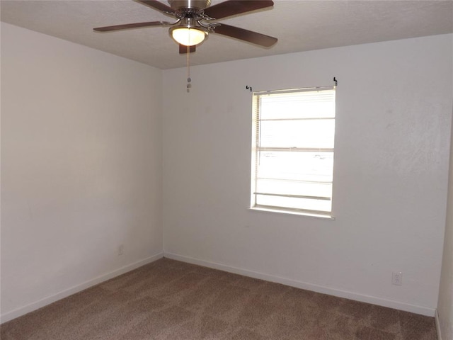 spare room with ceiling fan and dark carpet