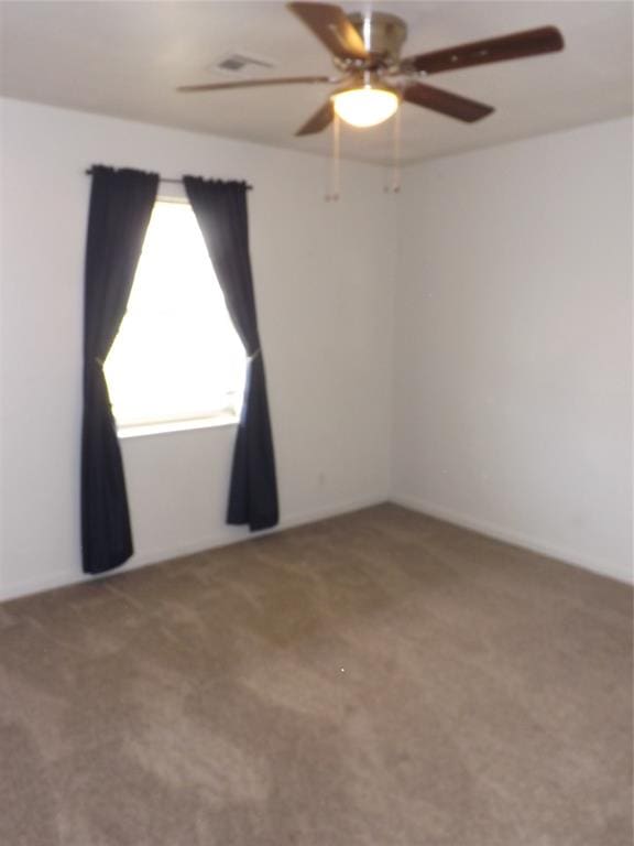 spare room featuring carpet and ceiling fan