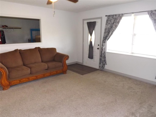 carpeted living room with ceiling fan