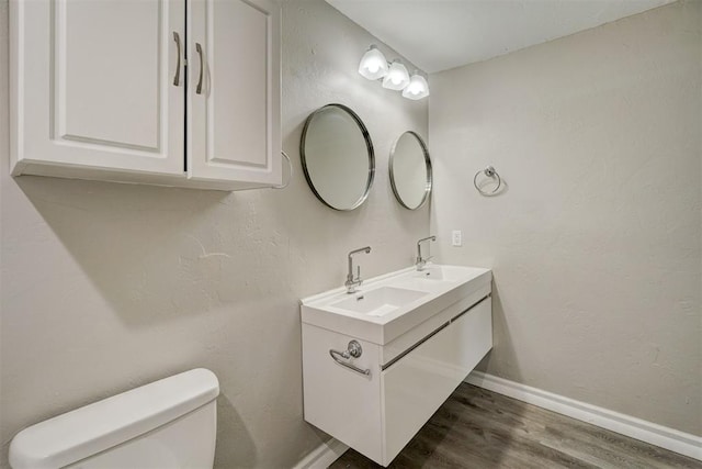 bathroom featuring wood-type flooring, vanity, and toilet