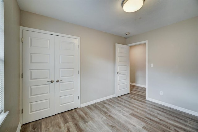 unfurnished bedroom featuring light hardwood / wood-style floors and a closet