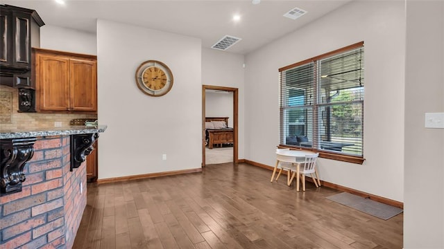 kitchen featuring light stone counters, wood-type flooring, and tasteful backsplash