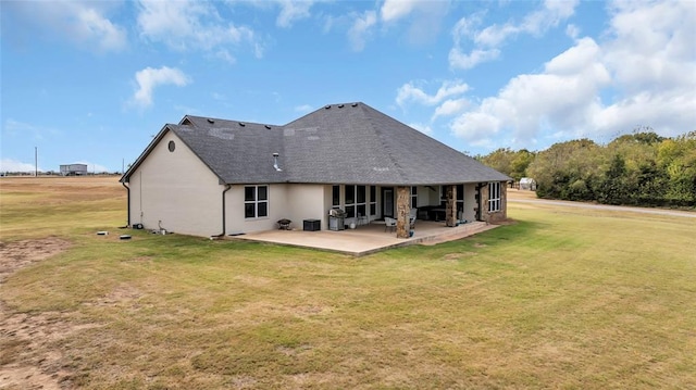 rear view of property featuring a lawn and a patio area