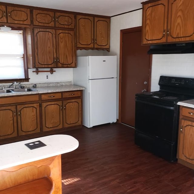 kitchen with black electric range oven, sink, dark hardwood / wood-style floors, white fridge, and extractor fan