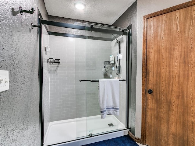 bathroom featuring an enclosed shower and a textured ceiling